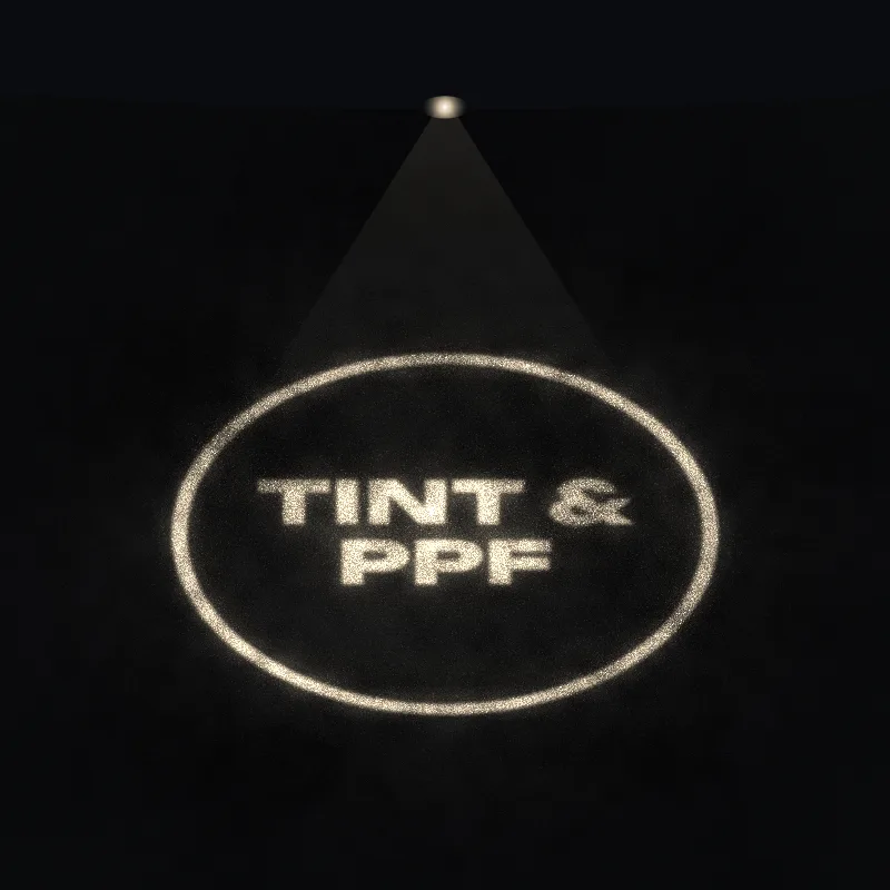 Sample shop logo reading Tint and PPF, glowing on asphalt